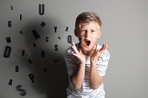 chlopiec wykrzykuje litery