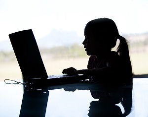 ciemna sylwetka dziecka korzystajacego z internetu