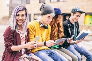 usmiechnieci nastolatkowie z tabletami i smartfonami
