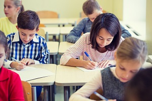uczniowie pisza test w klasie