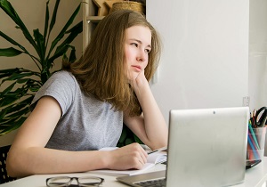 mloda dziewczyna zamyslona przy laptopie