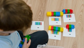 chlopiec korzysta z klockow lego na uczac sie matematyki
